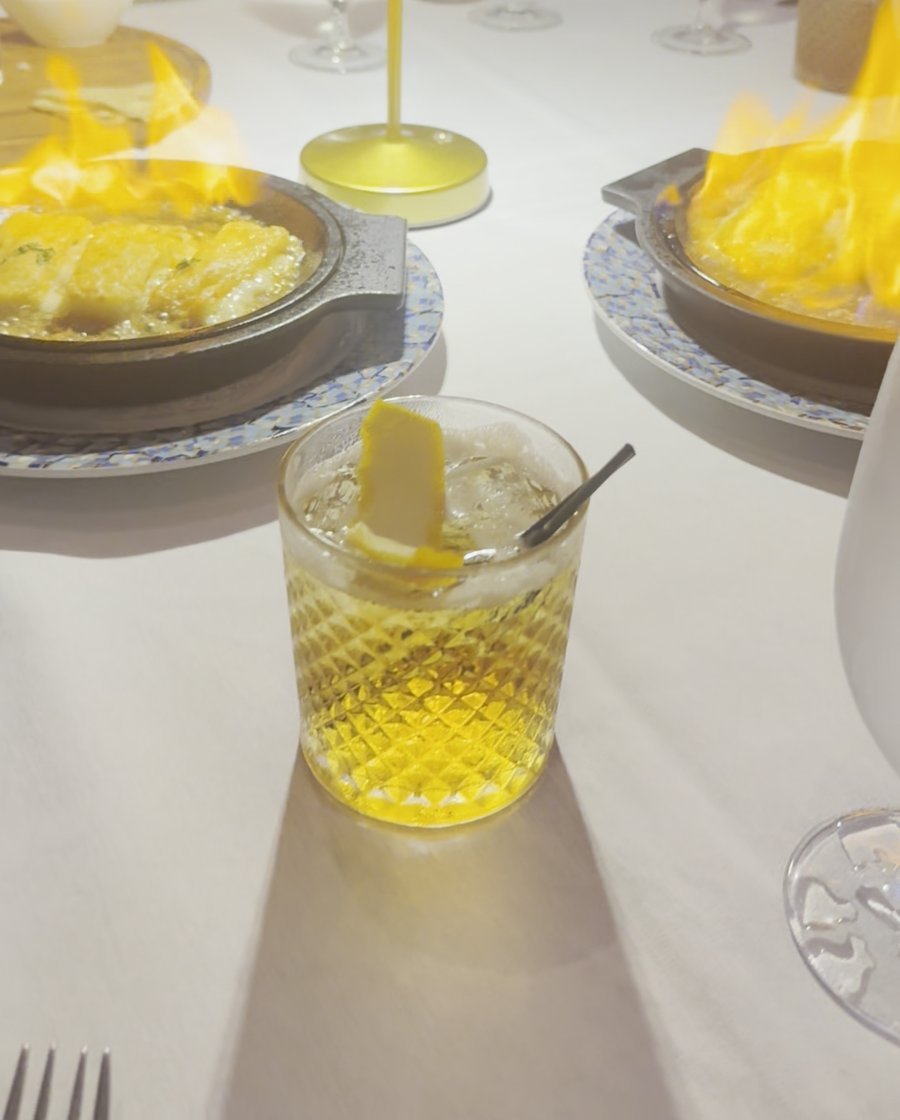 A Godfather cocktail in front of flaming saganaki at Estia
